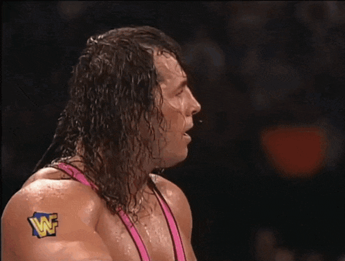 a close up of a wrestler 's face with a wwe logo on his shirt