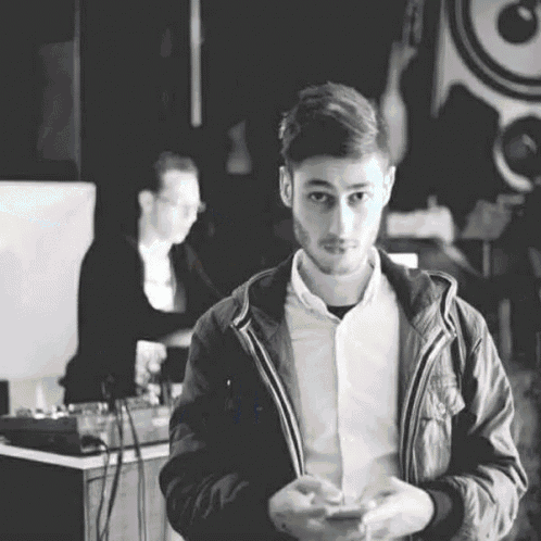 a black and white photo of a man standing in front of a dj .