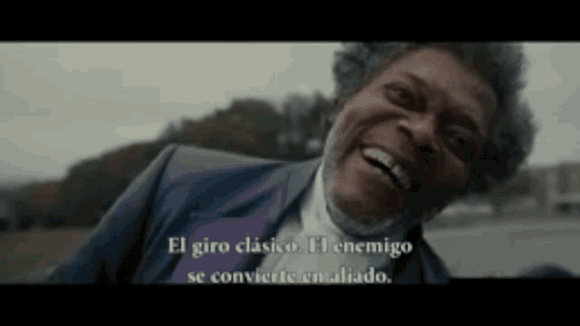 a man in a suit is smiling with the words el giro clasico el enemigo se convierte en aliado below him