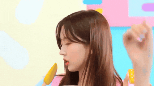 a woman is eating an ice cream cone with a colorful background behind her .