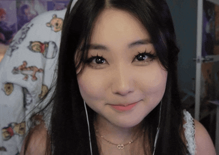 a woman wearing headphones and a necklace with the letter c on it
