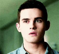 a close up of a young man 's face with a serious look on his face .