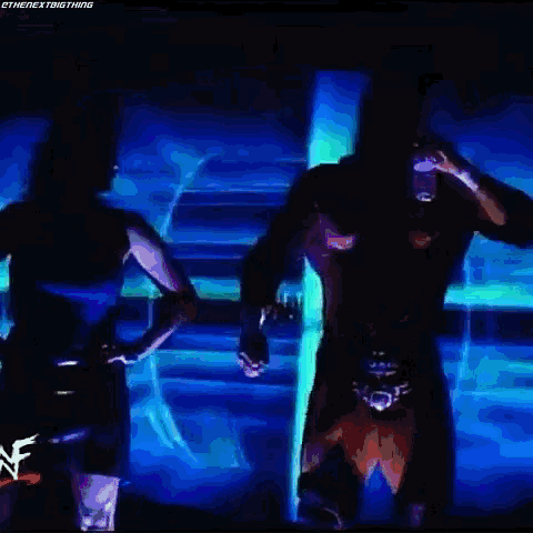 a man and a woman are standing in front of a screen that says wwe on it
