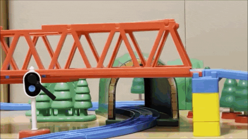 a toy train set with a red bridge and a sign that says 6 on it