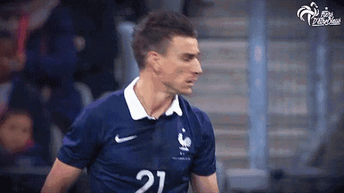 a soccer player wearing a blue and white jersey with the number 21 on it .