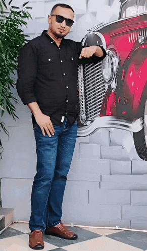 a man wearing sunglasses stands in front of a painting of a car