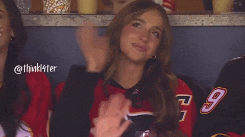 a woman wearing a number 9 jersey applauds