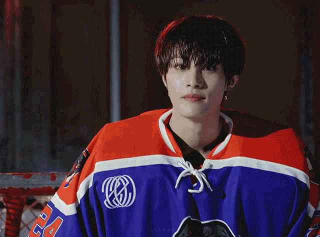 a young man wearing a blue red and white hockey jersey with the letter s on the front