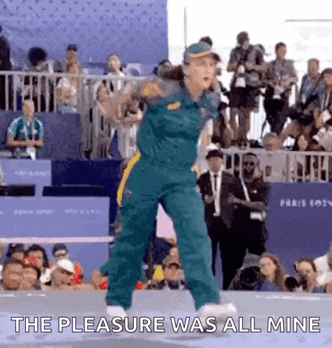 a woman is dancing in front of a crowd with the words `` the pleasure was all mine '' written on the screen .
