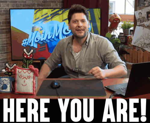a man sitting at a desk with the words here you are on the bottom