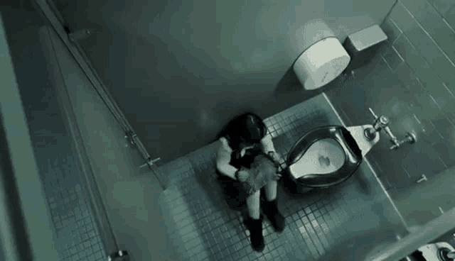 a person is standing on a tiled floor in a dark room in a dark room .
