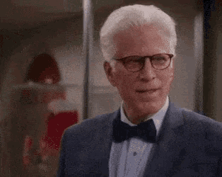 an older man wearing a suit and bow tie is laughing .