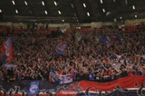 a blurred image of a crowd of people in a stadium with flags
