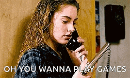 a woman is talking on a telephone while holding a gun .