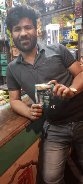 a man in a store holding a box that says free pack