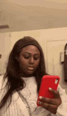 a woman is holding a cell phone in her hand .