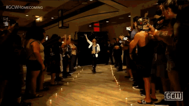 a group of people are gathered in a room with a sign that says gcw