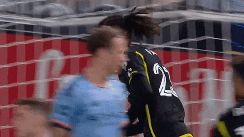 a soccer player with the number 22 on his jersey is being tackled by another player