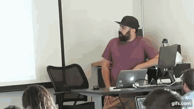 a man with a beard is giving a presentation to a group of people