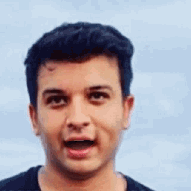 a young man is making a funny face with his mouth open and his eyes closed .