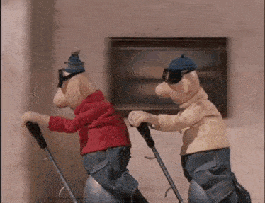 two cartoon characters are pushing a vacuum cleaner in front of a picture