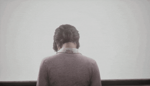 the back of a woman 's head with a bun on her hair