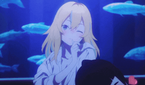 a girl with blonde hair is sitting in front of an aquarium
