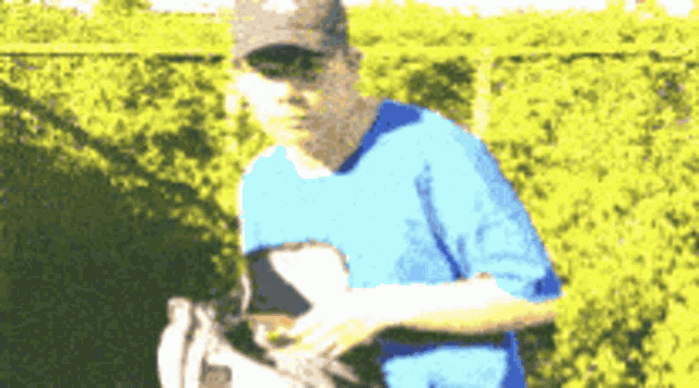 a blurry picture of a man wearing a blue shirt and a black hat
