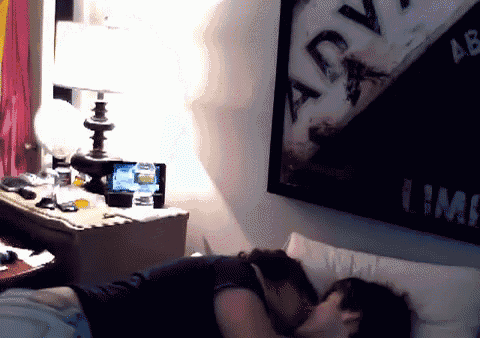 a man and a woman are kissing in a bedroom with a poster on the wall that says " lime "
