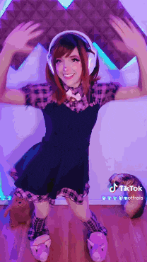 a girl wearing headphones and a plaid shirt is standing in front of a purple wall ..