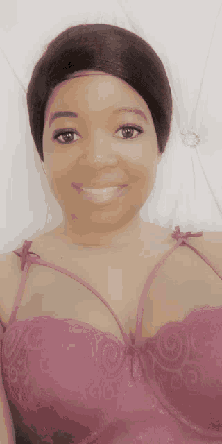 a woman is wearing a pink bra and smiling