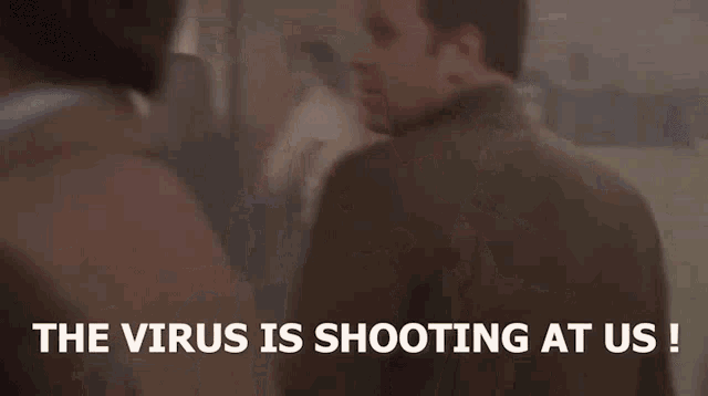 two men are standing next to each other in a room with the words `` the virus is shooting at us '' .