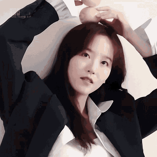 a woman in a suit holds an apple in her hair