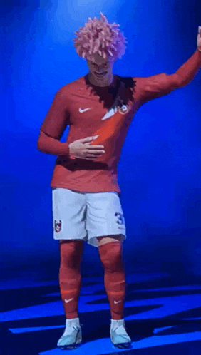 a soccer player wearing a red shirt and white shorts with the number 23 on the shorts