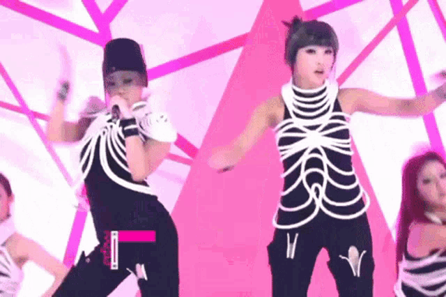 a woman in a skeleton costume is singing into a microphone on stage