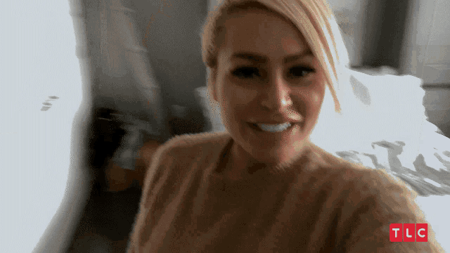 a woman taking a selfie with tlc written on the bottom right