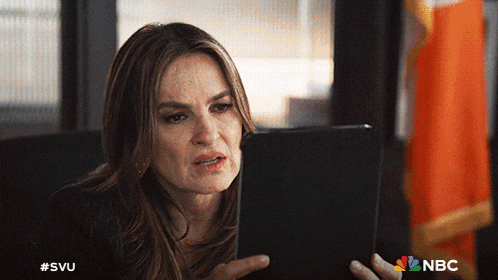 a woman looking at a tablet with the nbc logo in the background