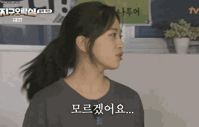 a woman with korean writing on her shirt is talking