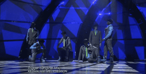 a group of men are performing on a stage and the song is trigger