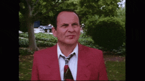 a man in a red suit and tie looks angry
