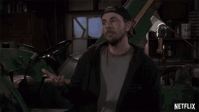 a man standing in front of a john deere tractor with netflix written on the bottom