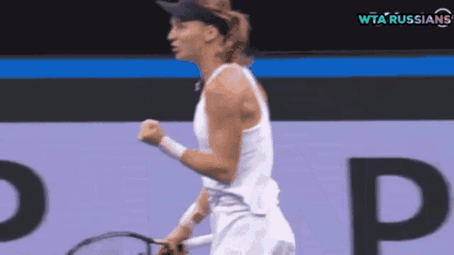 a woman is holding a tennis racquet on a court with a wta russians logo in the background