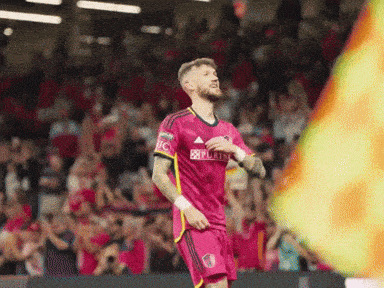 a soccer player wearing a pink jersey with the word purina on it