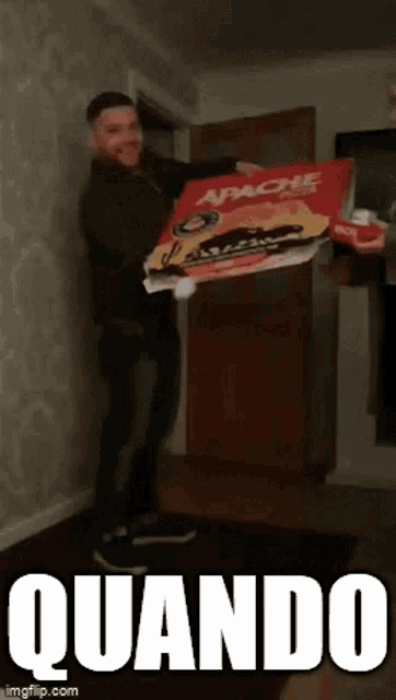 a man is holding a large pizza box that says apache
