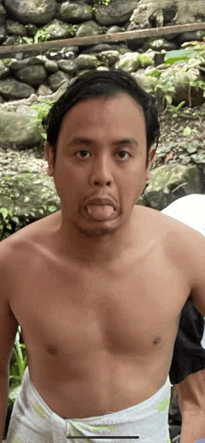 a shirtless man with his tongue sticking out