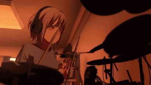a girl wearing headphones is playing drums