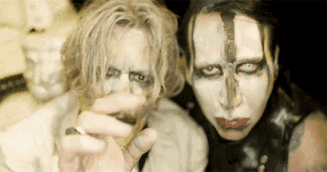 a man and a woman with white paint on their faces .