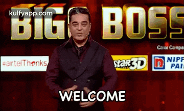 a man in a suit and tie stands in front of a big boss welcome sign