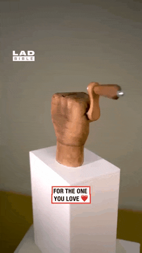a statue of a hand with a nail sticking out of it and a sign that says for the one you love