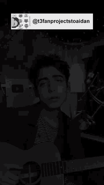 a black and white photo of a young man playing a guitar with the caption @t3fanprojectstoaidan